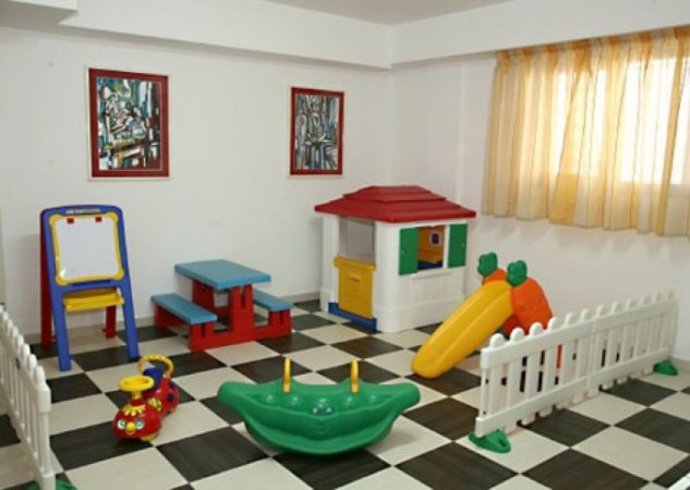 Sala giochi interna con giochi e casetta.
