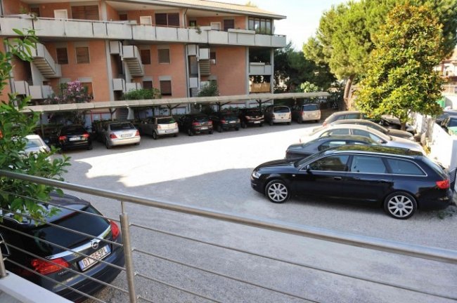 Parcheggio auto all'aperto con diversi veicoli.