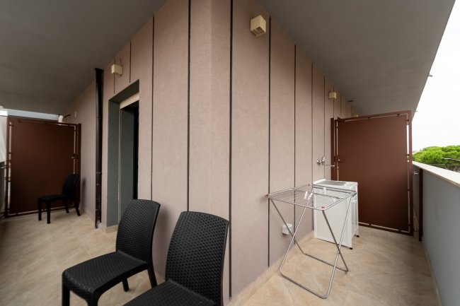 Balcone con sedie nere e stendibiancheria.