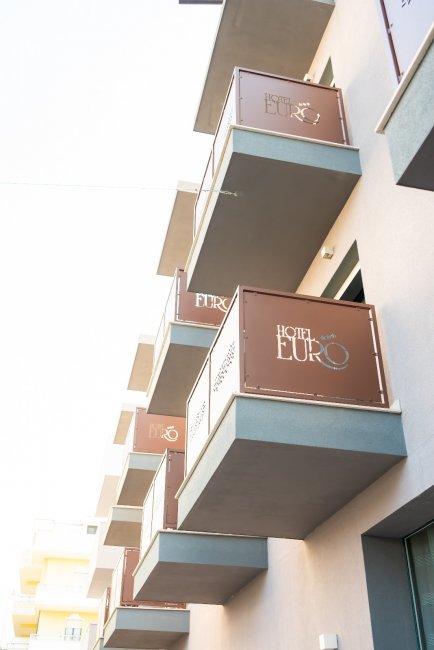 Facciata di hotel con balconi scuri.