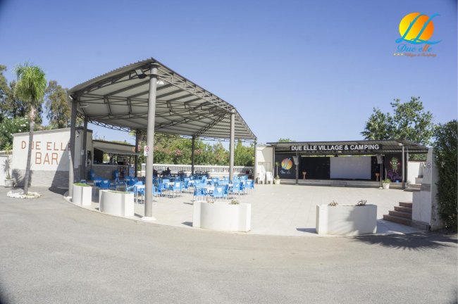 Area con bar all'aperto, sedie blu e tettoia a Due Elle Village & Camping.