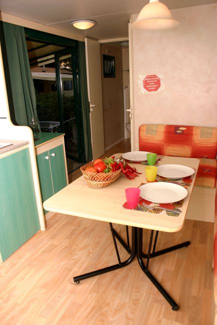 Tavolo da pranzo in una cucina, con piatti e bicchieri colorati.