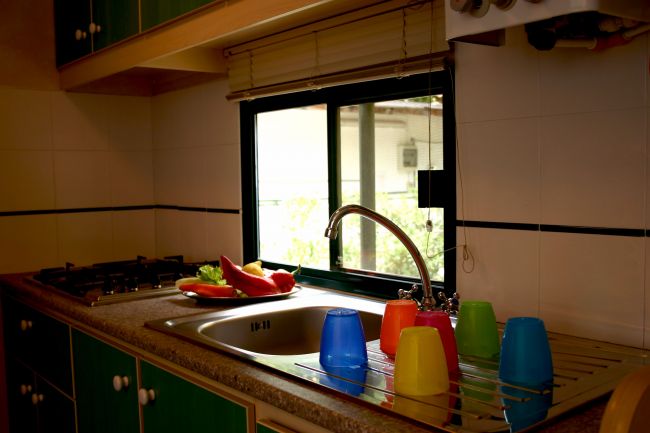 Cucina con lavello e bicchieri colorati.
