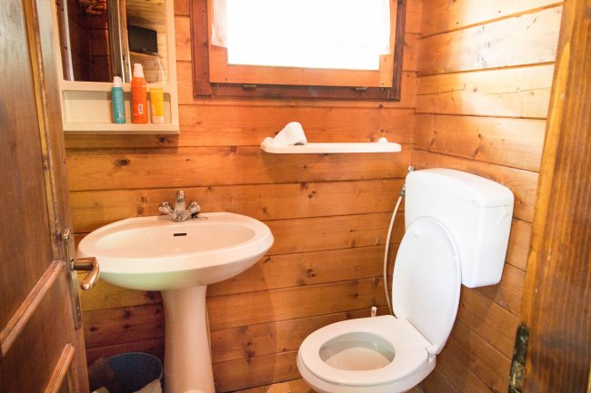 Bagno con lavabo e wc in legno.