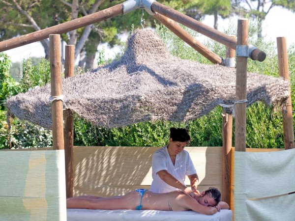 Massaggio all'aperto sotto un gazebo di paglia.