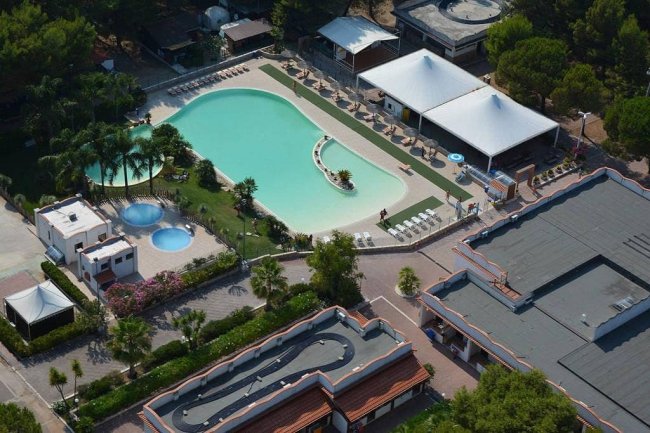 Vista aerea di un resort con piscine e giardini.
