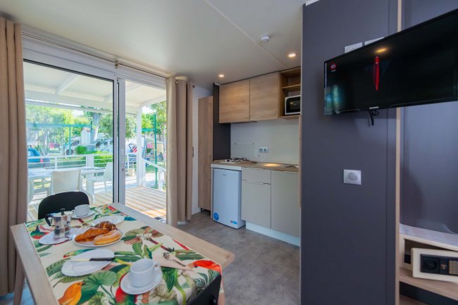 Cucina con tavolo apparecchiato e accesso alla veranda.