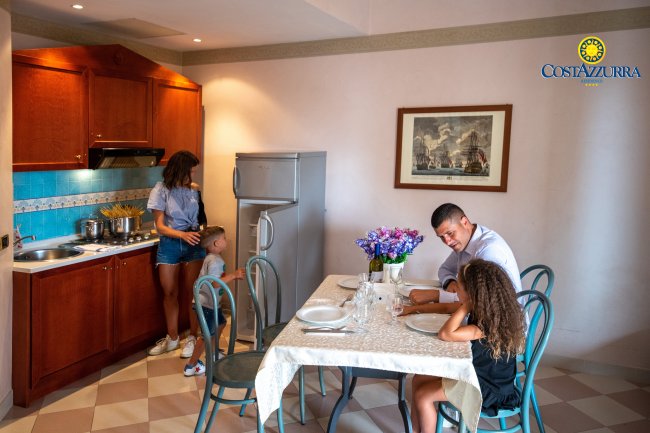 Famiglia riunita in cucina, donna con bambino.