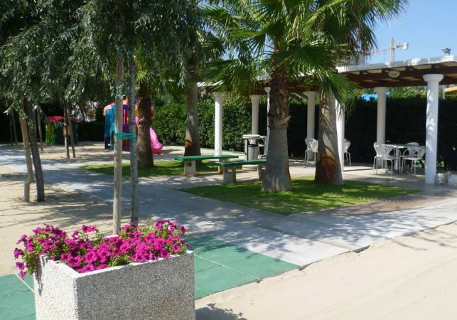 Area ombreggiata con tavolo e piante.