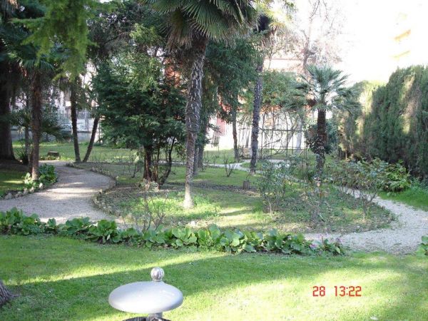 Giardino verde con alberi e sentieri curvi.