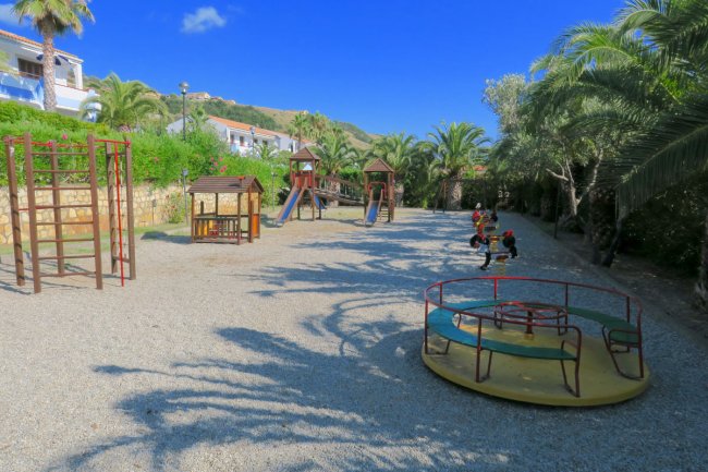 Parco giochi con scivoli e giostra.