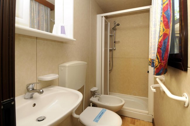 Bagno compatto con doccia, lavandino e bidet.