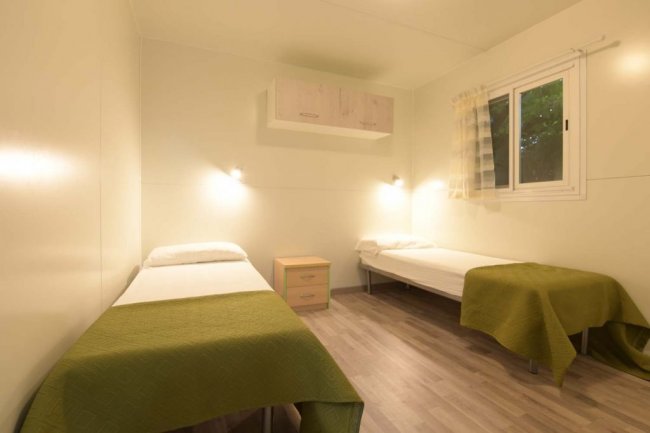 Camera con due letti singoli e comodino centrale.