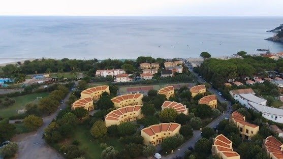 Complesso residenziale con tetti rossi vicino al mare.