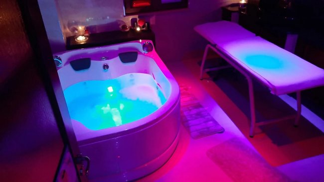 Vasca idromassaggio illuminata in un ambiente rilassante.
